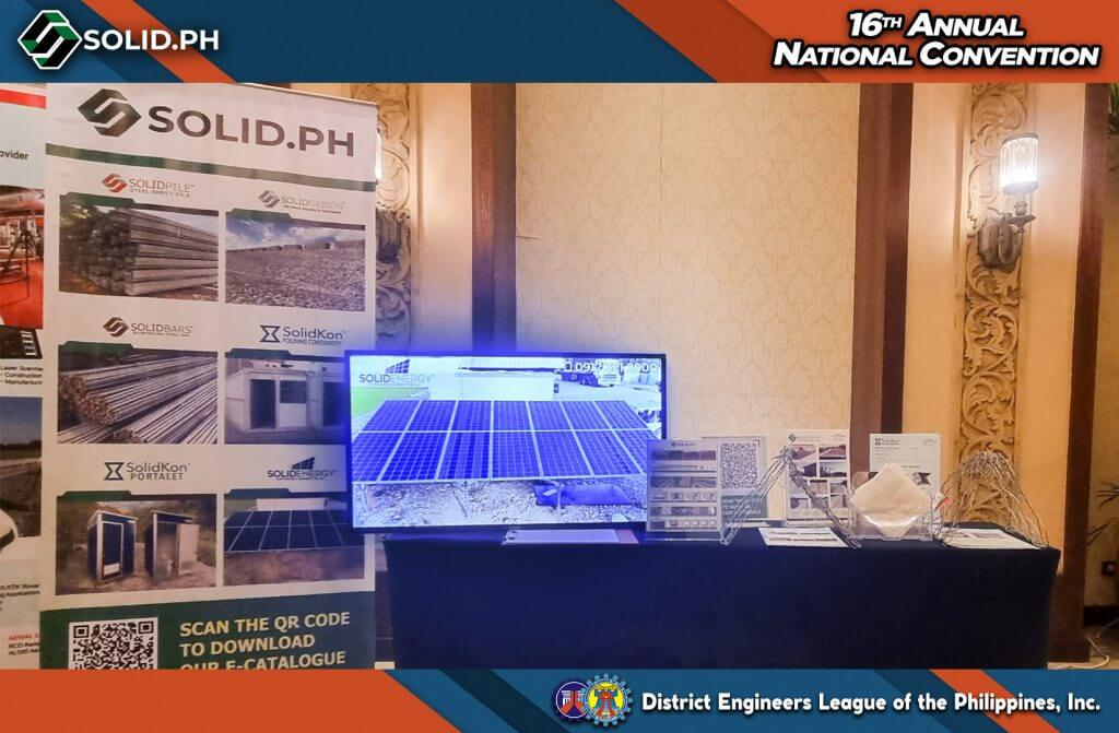 SOLID.PH booth at the 16th Annual National Convention, featuring a banner, monitor displaying solar panels, and product samples.